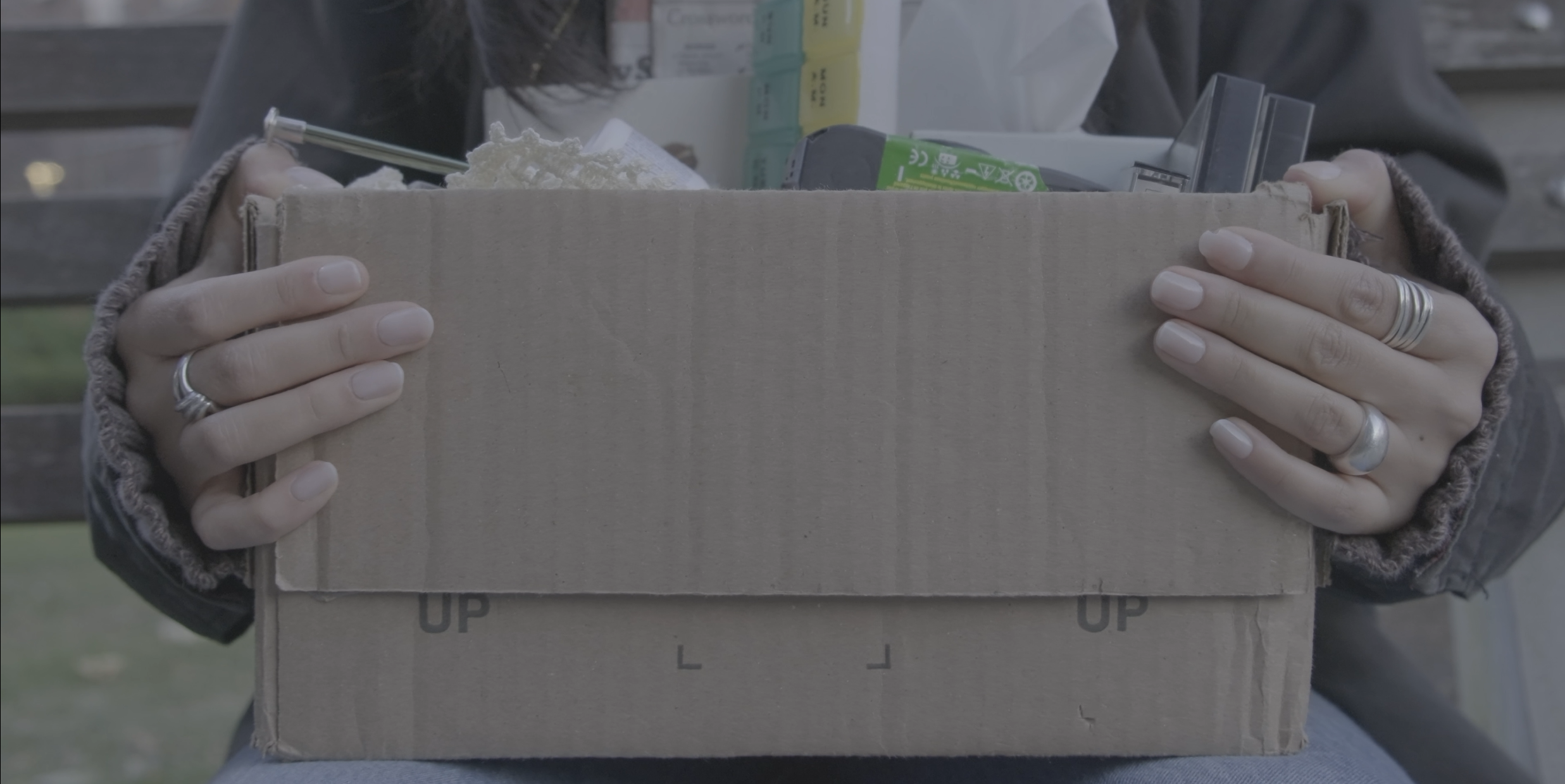 A young woman holds a box of her mother's belonglings.