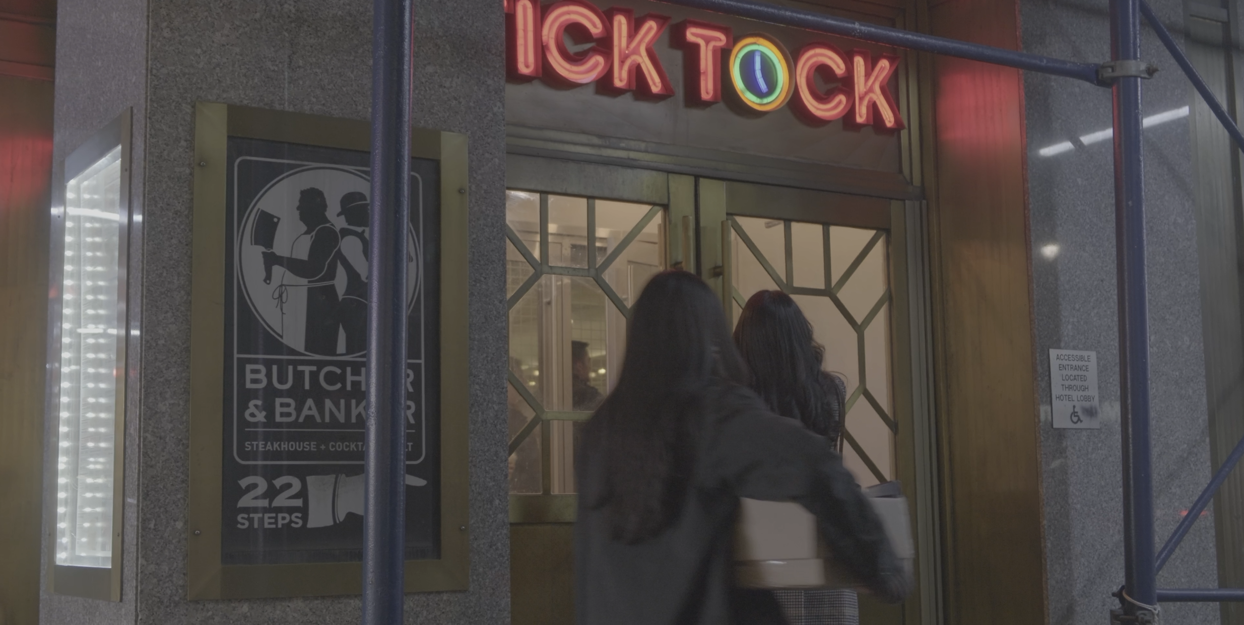 Two young women enter a diner.